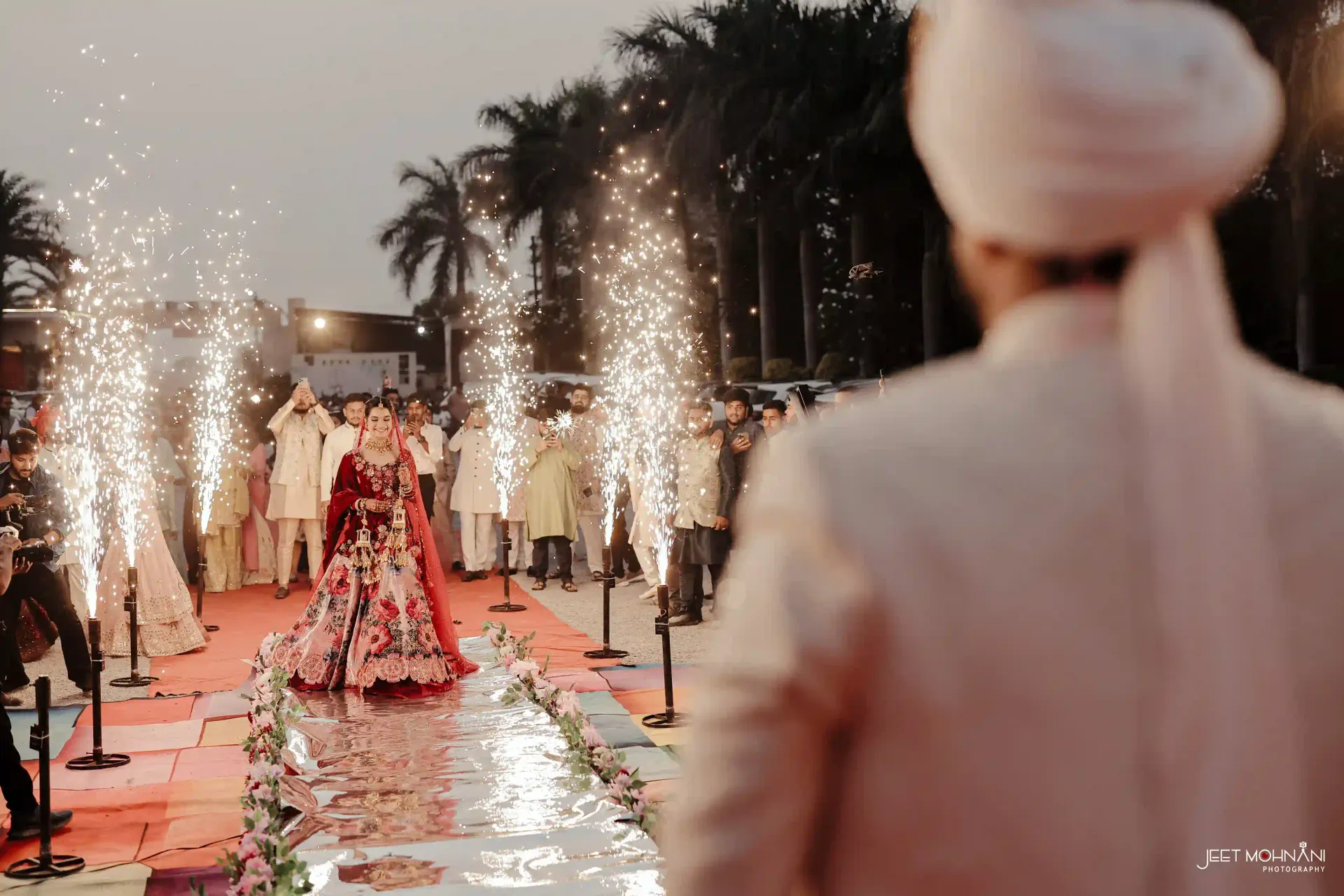 A bride walking the aisle through sparklers at dusk