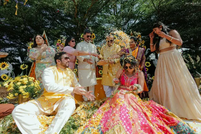 The haldi, family throwing flowers over the couple