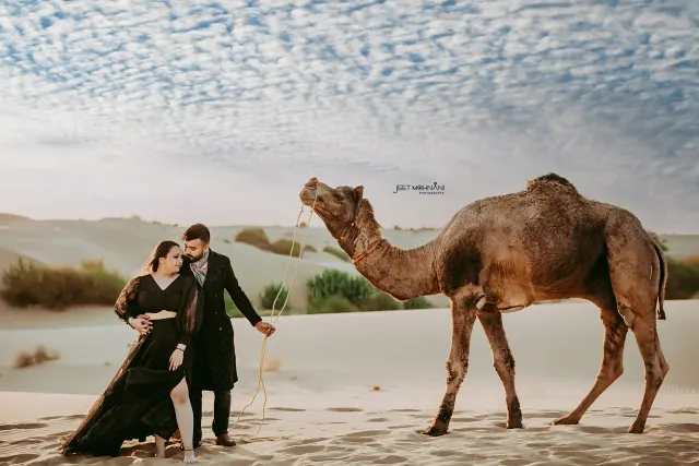The couple with a camel on the dunes