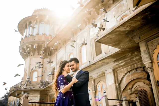 The couple embracing before an old palace facade